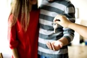 Una pareja joven recibe las llaves de su casa recién comprada. PQS / CCO