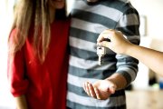 Una pareja joven recibe las llaves de su casa recién comprada. PQS / CCO