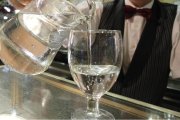 Un camarero sirve un vaso de agua en la barra de un bar