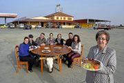 Mari Carmen Amez, en primer término, con un chuletón de búfalo, y su familia detrás. De i. a d.: Miriam, Carlos, Eduardo, Camino, Laura, Juan y Ana.-ARGICOMUNICACIÓN