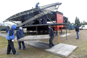 Una cuadrilla de operarios instala, ayer, el escenario principal en la campa de la antigua Hípica Militar.-J.M. Lostau