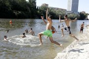 Un grupo de jóvenes se baña en la playa del Pisuerga este martes pese a no ser apta según la Junta. J.M. LOSTAU