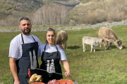 Aída y David frente a terneras de raza parda de su explotación con algunas de las piezas de carne que comercializan online y sirven en su restaurante. / E.M.