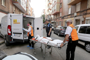 Los servicios funerarios retiran los cadáveres de dos mujeres de una vivienda de la calle Linares 32, en el barrio de la Rondilla de Valladolid.- Ical