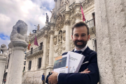 Víctor Cazurro Barahona sujeta sus dos últimos libros sobre la protección de datos frente a la fachada de la Facultad de Derecho de Valladolid../ ARGICOMUNICACIÓN