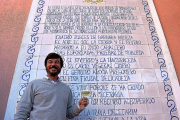Juan de Benito, junto al soneto de su padre dedicado al vino verdejo, que luce en la pared del patio central de su bodega navarresa.-ARGICOMUNICACIÓN