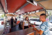 Un joven conversa con la encargada de una de las casetas festivas de la Feria de Día de Laguna, ayer.-MIGUEL ÁNGEL SANTOS