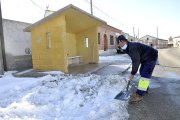 Julián, uno de los operarios municipales que acondicionan las calles y accesos a base de pala y sal, aparta la nieve de las inmediaciones de la parada del autobús, ayer en Fuente el Sol. - SGC