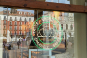 La plaza Mayor reflejada en el escaparate de Manolo Bakes. J.M. LOSTAU