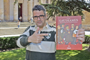 El ilustrador salmantino Tomás Hijo, en la Plaza de Anaya de su ciudad, con su último trabajo editorial, Gaudeamus, un libro de viñetas dedicado a los ocho siglos de historia de la Universidad de Salamanca.-ARGICOMUNICACIÓN