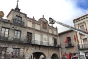 Los bomberos afianzan la escultura superior de la Casa de los Arcos.-EL MUNDO