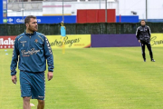 Chica anda en zapatillas por el césped de los Anexos ante la mirada de Rubi, durante el entrenamiento del lunes-Miguel Ángel Santos