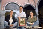 Sara, Santi y Macarena posan en el patio del restaurante con una fotografía tomada en el mismo lugar años atrás y dos de los platos de su carta-