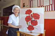 La cocinera Hortensia Eulalia dos Santos, en el comedor del Café-Fado La Portuguesa, situado en la Calle Estación de Valladolid, con una imagen de los claveles, símbolo de Portugal y también de su restaurante.-ARGICOMUNICACIÓN