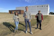 En primer plano, Daniel Torio; a su espalda, la enóloga Silvia; y delante de la fachada de la nueva bodega, su padre Ángel Torio.