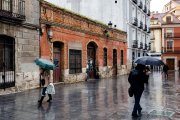 Varios viandantes se protegen de la lluvia en el centro de Valladolid