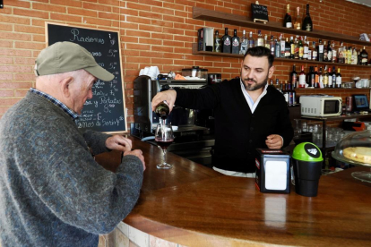 Catalin, arrendatario del nuevo bar municipal de Castronuño, atendiendo a un vecino del pueblo