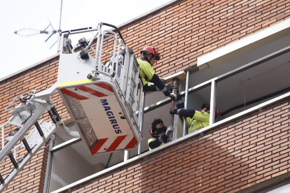 Los bomberos apuntalan una ventana para evitar la caída de cascotes