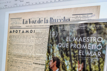 Un ordenador de la Biblioteca de Castilla y León muestra un ejemplar del periódico 'La Voz de la Bureba' ante el cartel de la película 'El maestro que prometió el mar', sobre la figura de Antonio Benaiges.