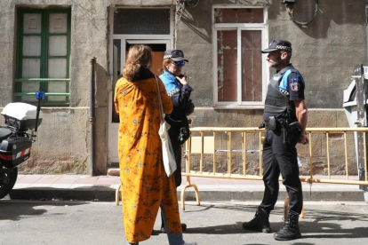 La trabajadora social del Ayuntamiento habla con dos agentes de Policía en su primera visita a los okupas, el lunes. J.M.LOSTAU