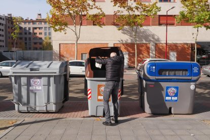 Un hombre sale a tirar la basura a un contenedor en Valladolid