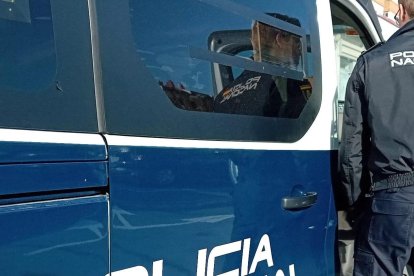 Un agente de la Policía Nacional delante de un furgón.