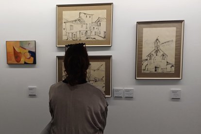 Una mujer contempla algunas obras de la exposición