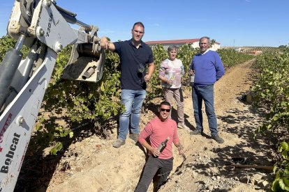 Marga Vidal y Miguel Ángel Vidal con sus hijos Daniel y Sergio en la zanja donde se crió bajo tierra el vino de la uva de la propia viña.
