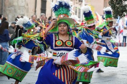 Miembros de colectivos hispanos residentes en Valladolid desfilan ante el Palacio Real ante la mirada del público.