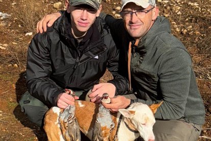 Dos cazadores, padre e hijo, con su cupo de una perdiz en un coto salmantino.
