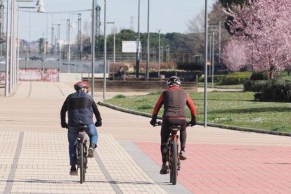 Dos hombres recorriendo la ciudad en bicicleta y disfrutando del buen tiempo