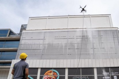 Un operario maneja un dron para limpiar la fachada del centro comercial Vallsur.