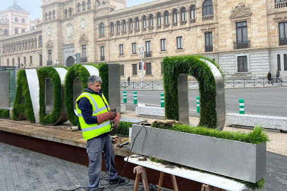 Un operario instala una nueva letra 'i' en el cartel vegetal de la Plaza de Zorrilla. E. M.