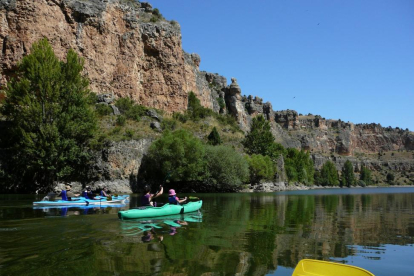 Excursionistas realizan una ruta en canoa por el cañón del río Lobos. A la derecha, panorámica de las Arribes del Duero.-FUNDACIÓN PATRIMONIO NATURAL