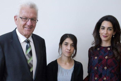 El jefe del Gobierno regional de Baden-Wurttemberg, Winfried Kretschmann, la joven yazidi Nadia Murad y la abogada Amal Clooney, en Stüttgart.-EFE / BERND WEISSBROD