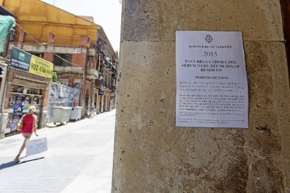 Uno de los anuncios informativos sobre el cobro de la tasa de basura puesto en uno de los portales de la calle Zúñiga.-Miguel Ángel Santos