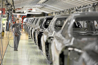 Una trabajadora revisa una cadena de automóviles del modelo Megane en la fábrica de Renault en Villamuriel.-ICAL
