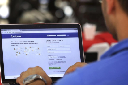 Un hombre entra en su página de Facebook en un restaurante en Brasilia, este miércoles. /-AP / ERALDO PERES