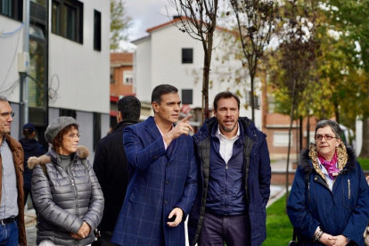 Pedro Sánchez y Óscar Puente conversan en el barrio de Pajarillos, rodeados del resto del equipo de la formación socialista.-J.M. LOSTAU
