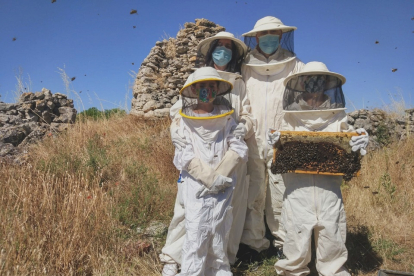 Una familia posa con un panal durante su visita al Aula de las abejas del Cerrato. E.M.