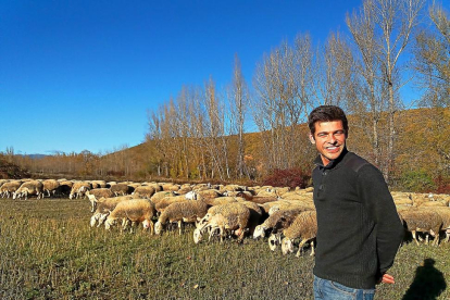 Javier Manzano Figal, ganadero leonés de 29 años, con sus ovejas en el Valle del Curueño.-E.M.