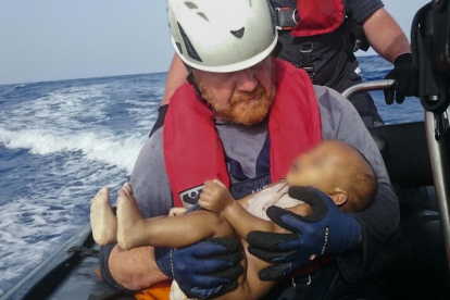 El bebé ahogado en los brazos del socorrista alemán Martin.-AP