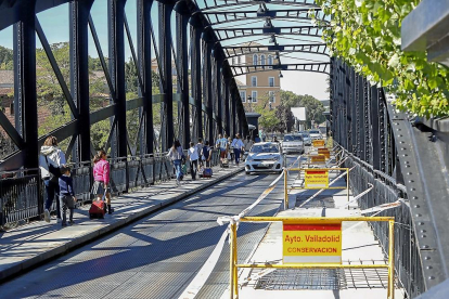 Vallas y balizas impiden el paso en una de las aceras del Puente Colgante, ayer, durante el inicio de las obras de reparación.-J.M. LOSTAU