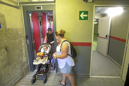 Una familia accede al aparcamiento por el ascensor de la entrada principal.-J.M. LOSTAU