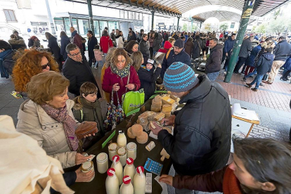 Varios clientes compran en el puesto de quesos del Ecomercado de plaza España. - E.M.