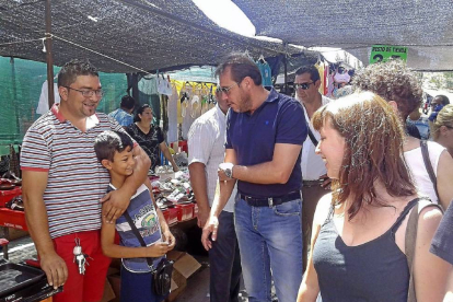 Óscar Puente conversa con un vendedor ambulante y su hijo, en el mercadillo del estadio.-El Mundo