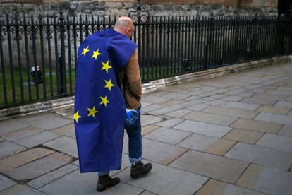 Un hombre con la bandera de la UE camina por una calle de Londres tras participar en una protesta en contra del 'brexit'.-AFP / JUSTIN TALLIS
