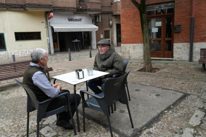 Javier Pascual dueño sentado con un vecino en la terraza del bar Woody de la plaza de los Ciegos - J.M. LOSTAU