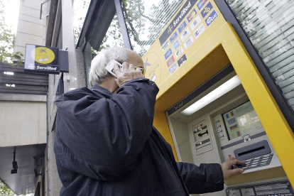 Una persona mayor utiliza el cajero automático de una sucursal bancaria.- ALBERTO CUELLAR