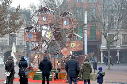 Familiares observan a niños montados en la noria artesanal instalada en la Plaza Mayor de Medina del Campo.-S. G.